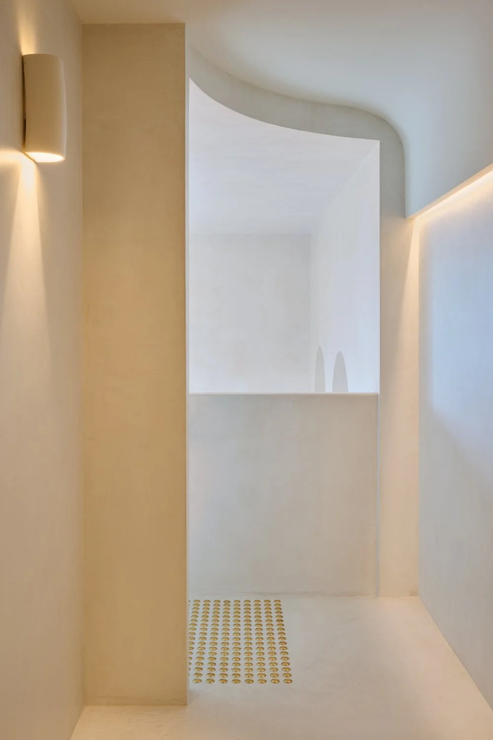Minimal pale wall cabinet and softly lit plaster wall at Sculpt Skin Clinic