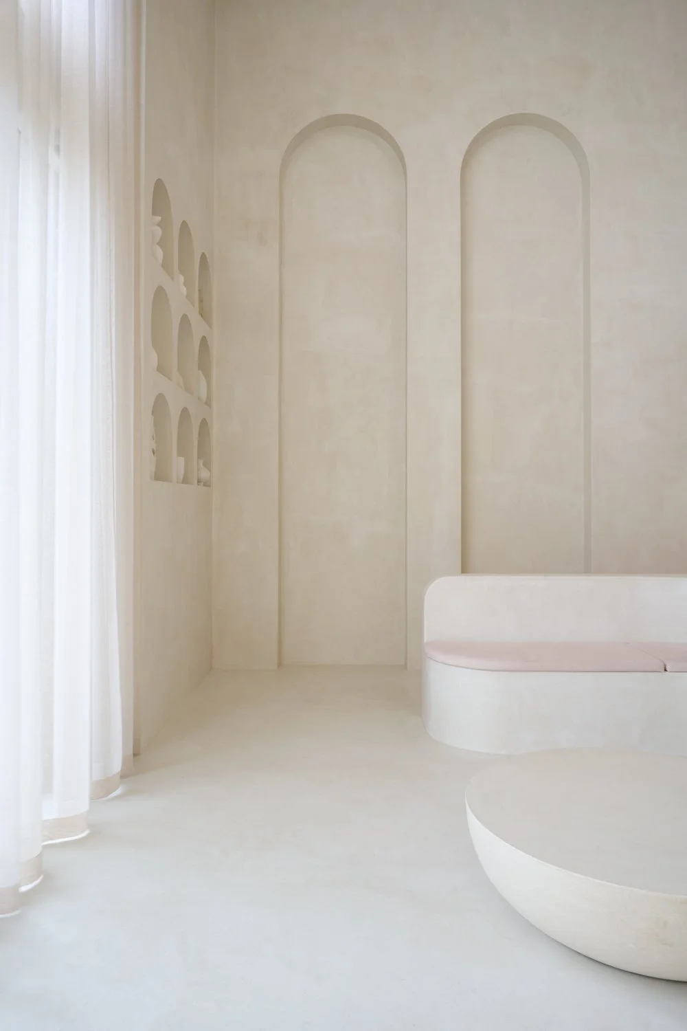 Pale curved reception desk against textured walls at Sculpt Skin Clinic