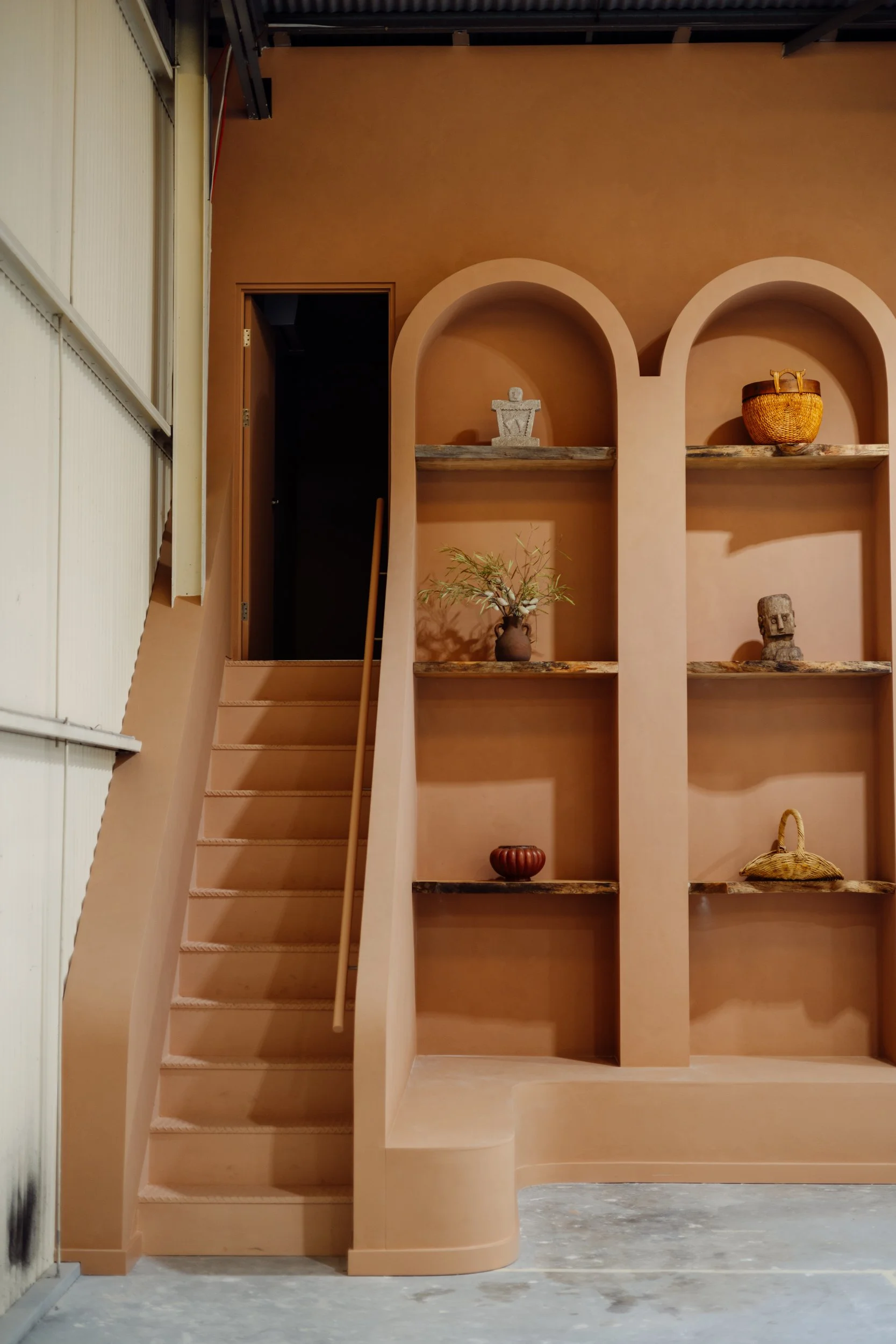 Stairs beside built-in arched display shelves at Stepney Warehouse