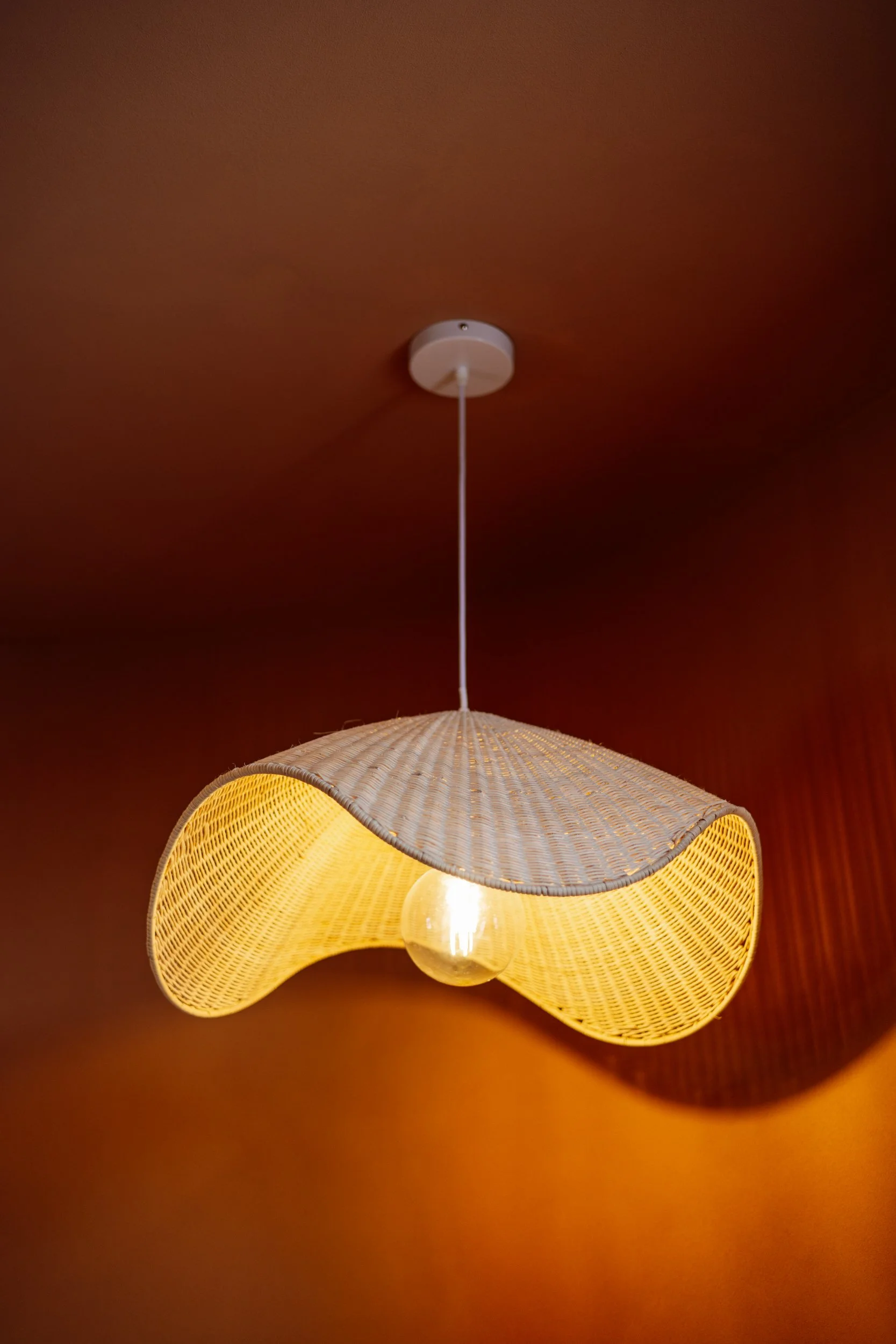 Sculptural woven pendant light against a terracotta ceiling at Stepney Warehouse