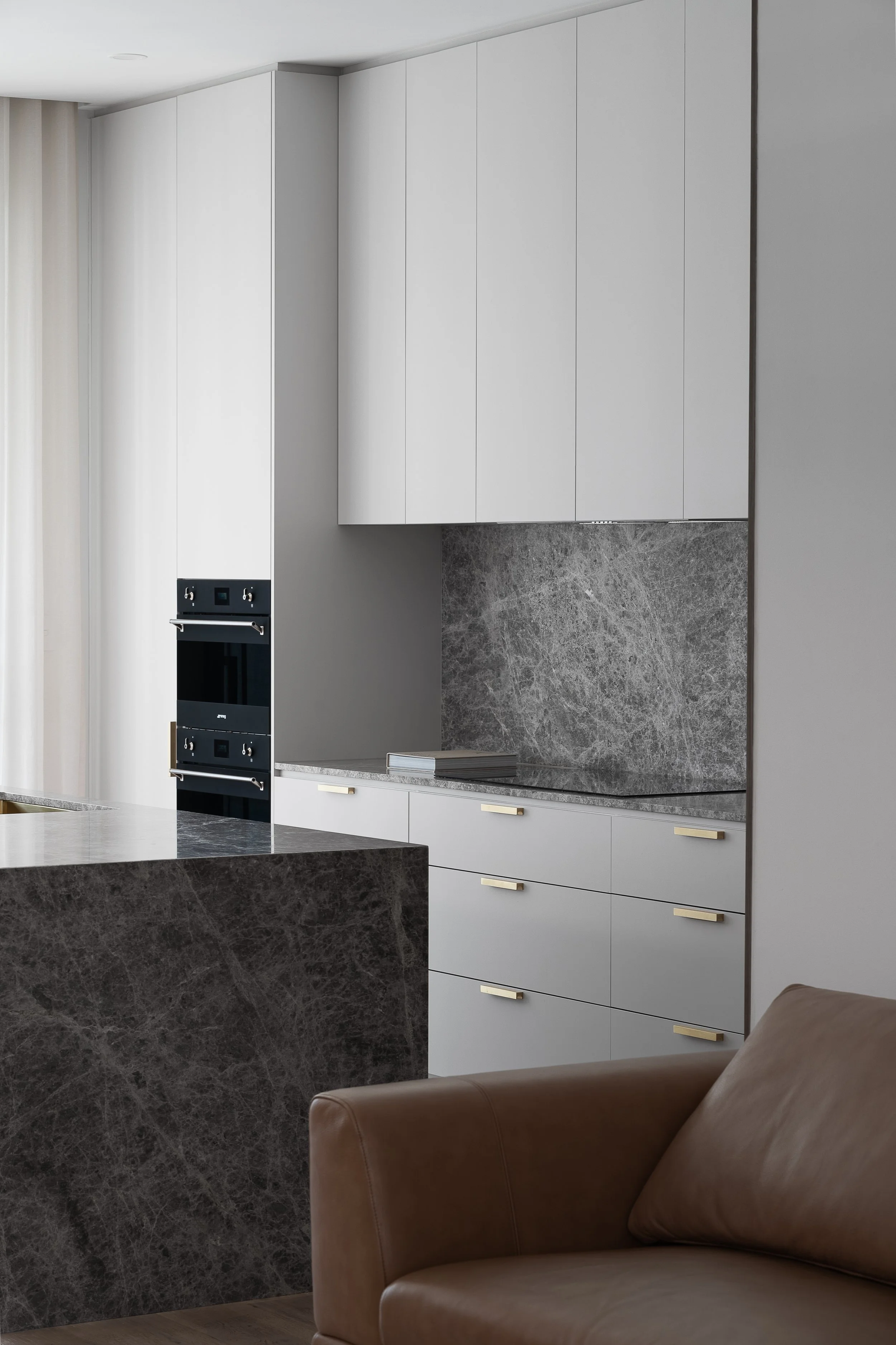 Pale kitchen cabinetry with stone benchtops and an integrated oven in Glynde
