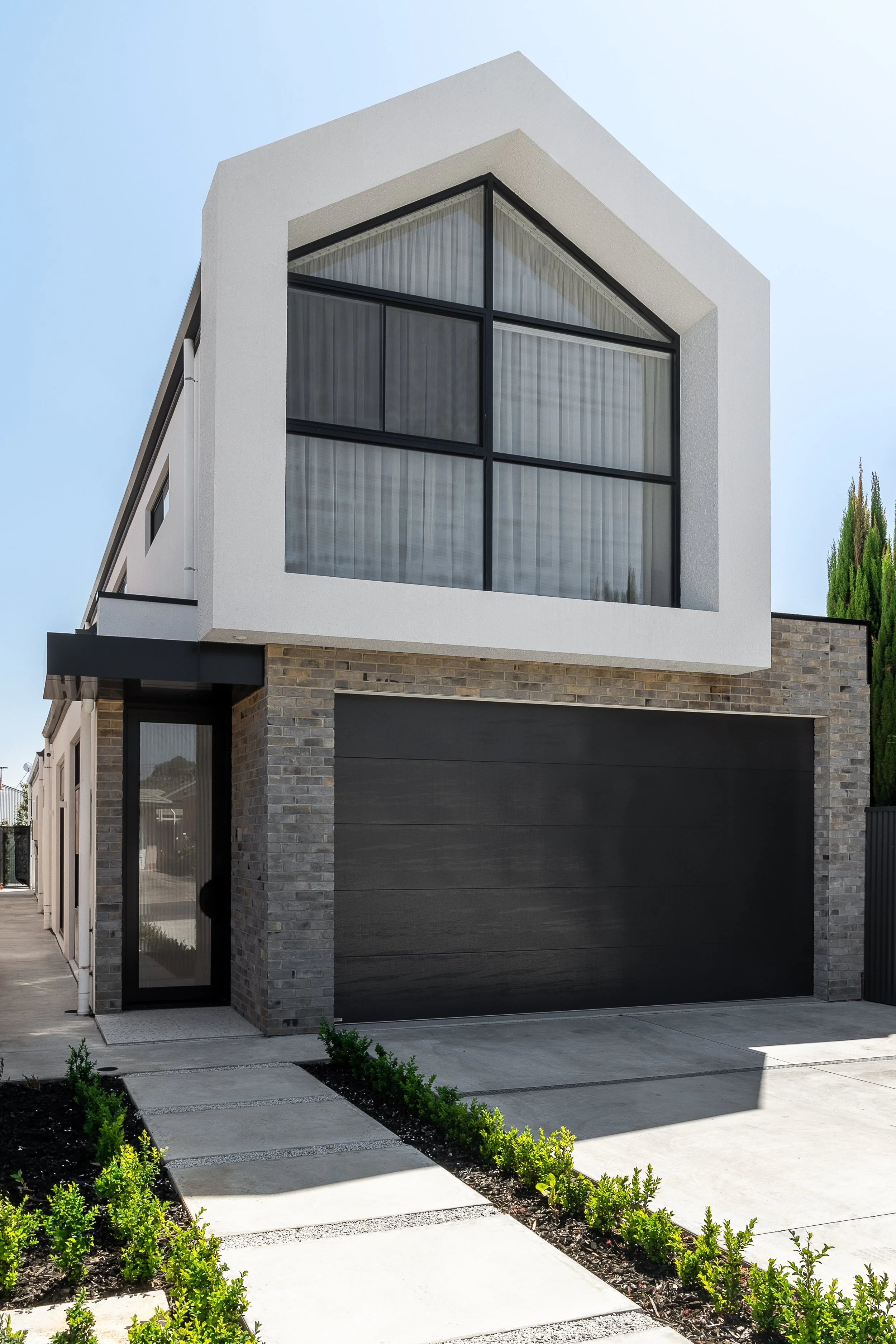 Gabled upper-storey façade above textured grey brickwork at the Glynde home
