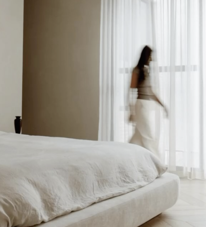 Light-filled bedroom with white bedding and sheer curtains