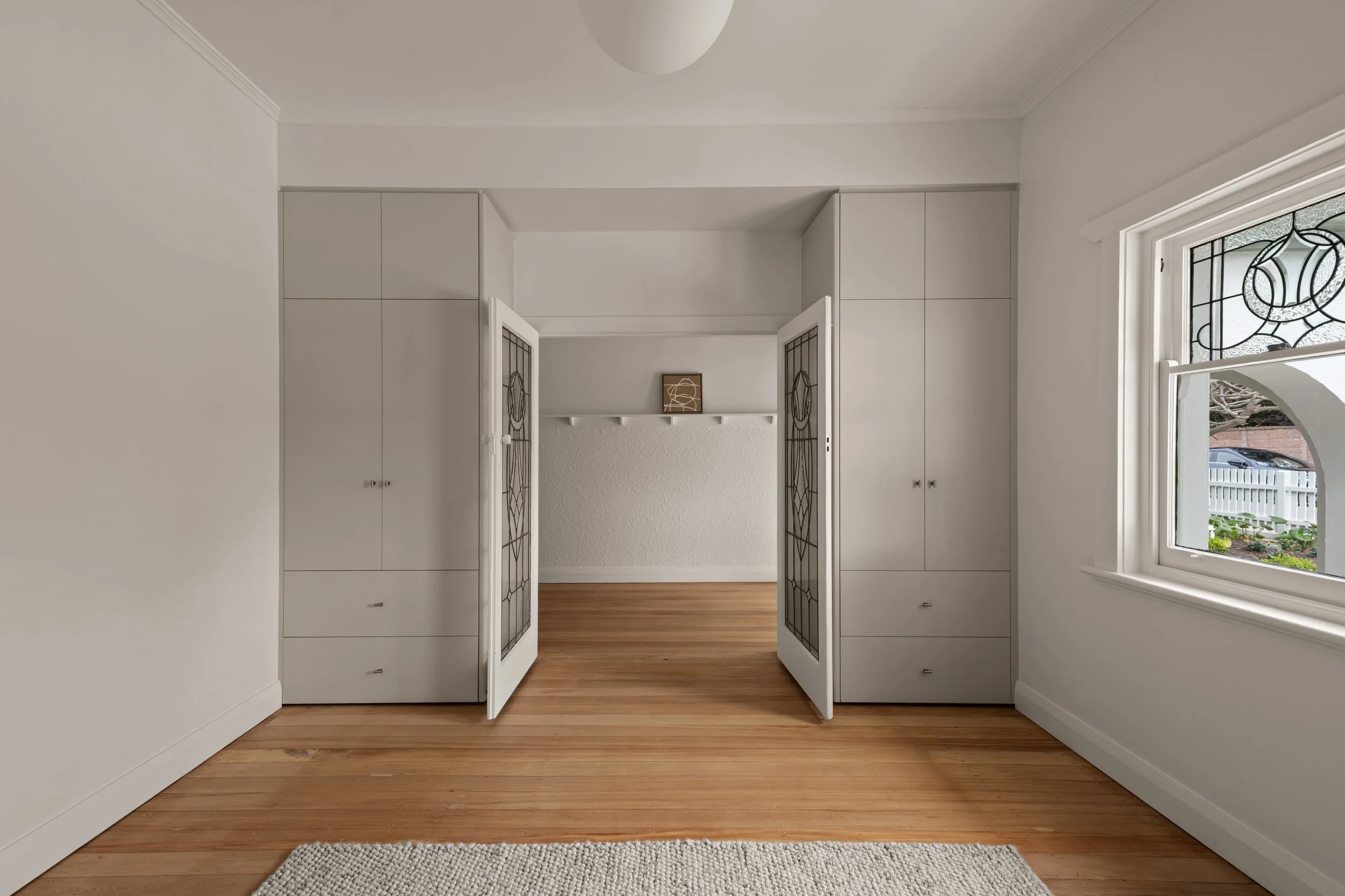 Timber-floored entry with white doors and original ceiling details in Glenelg North