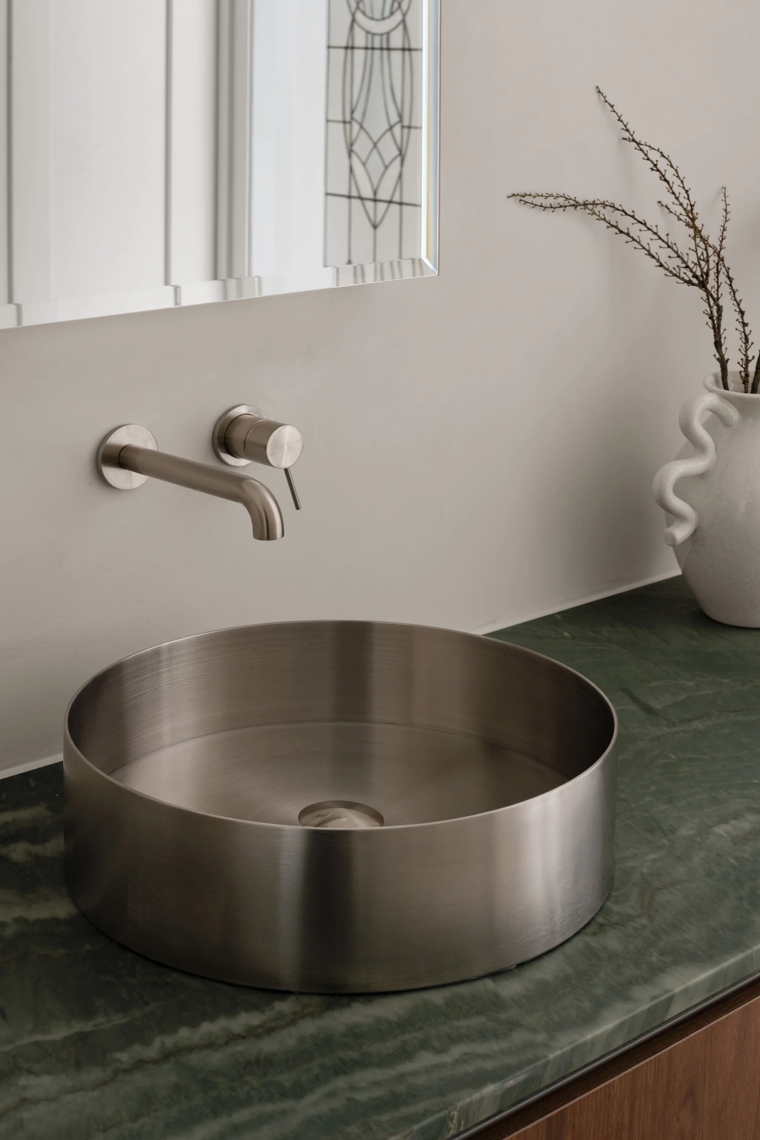 Glenelg North bathroom with a round metal basin, green stone vanity top and leadlight mirror