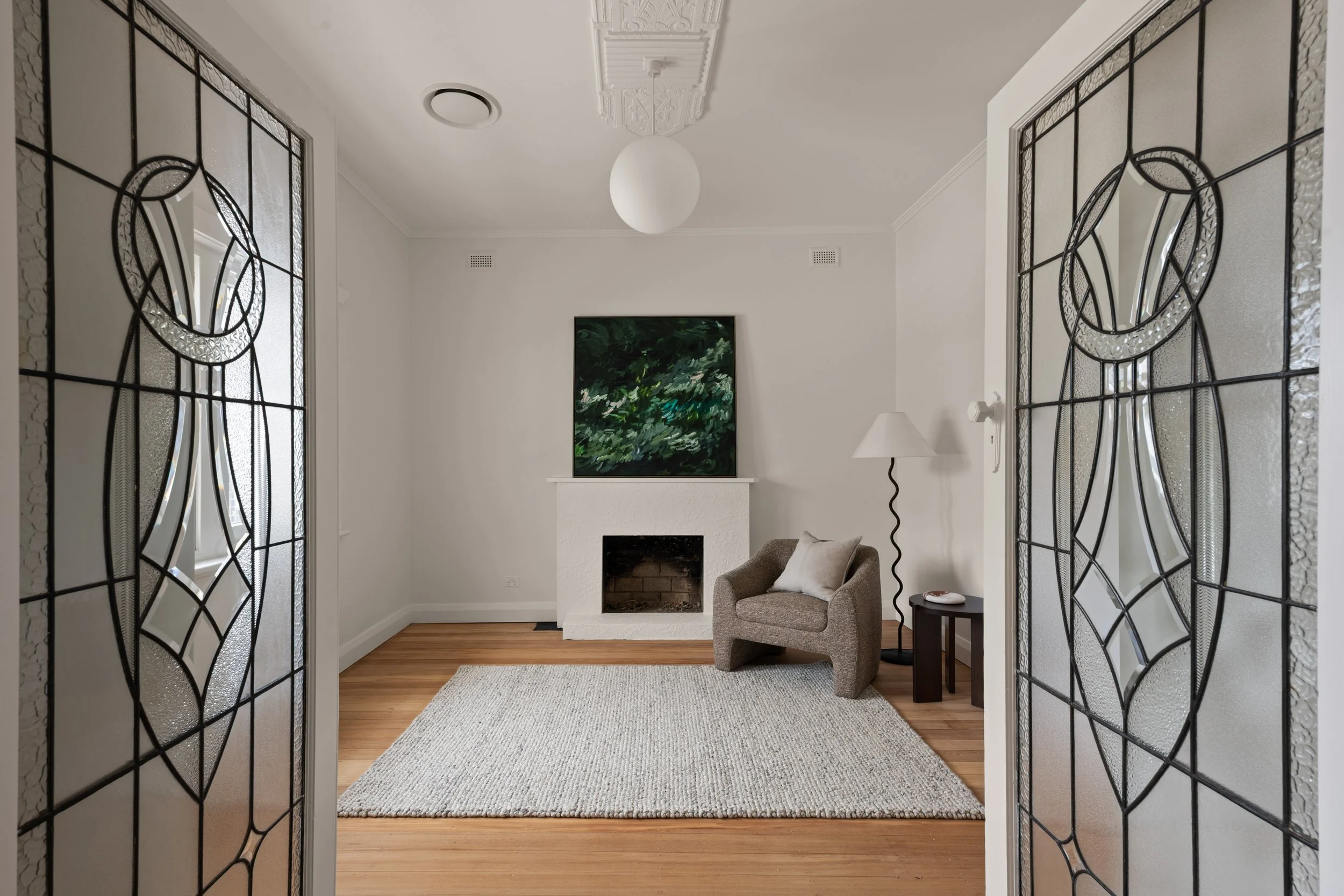 Glenelg North sitting room with a fireplace, green artwork and decorative ceiling