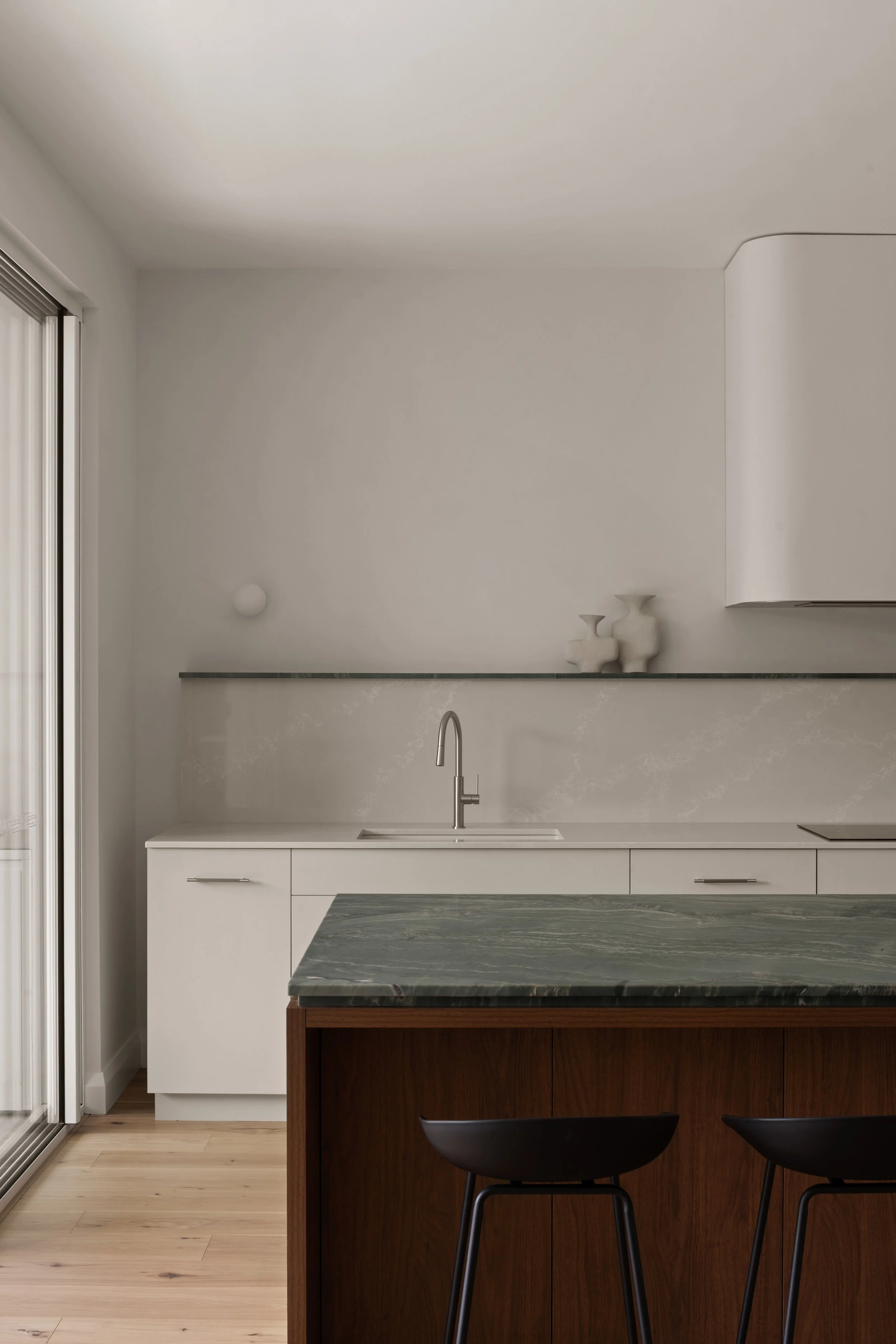 Green stone kitchen benchtop beneath pale cabinetry in Glenelg North