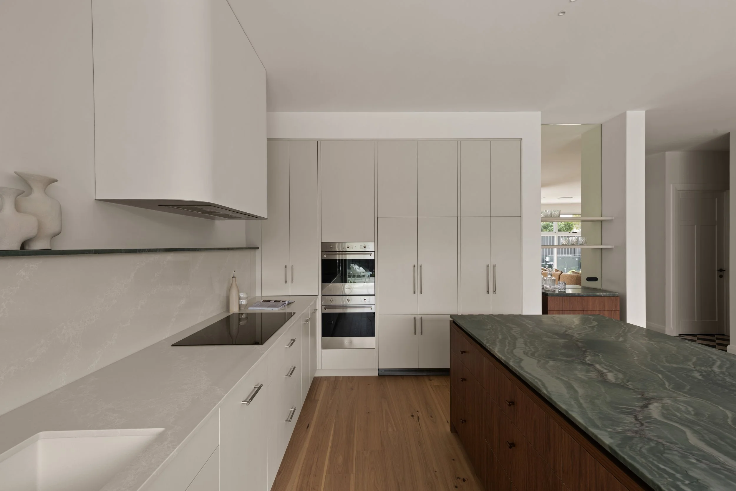 Pale kitchen cabinetry and green stone island benchtop in Glenelg North