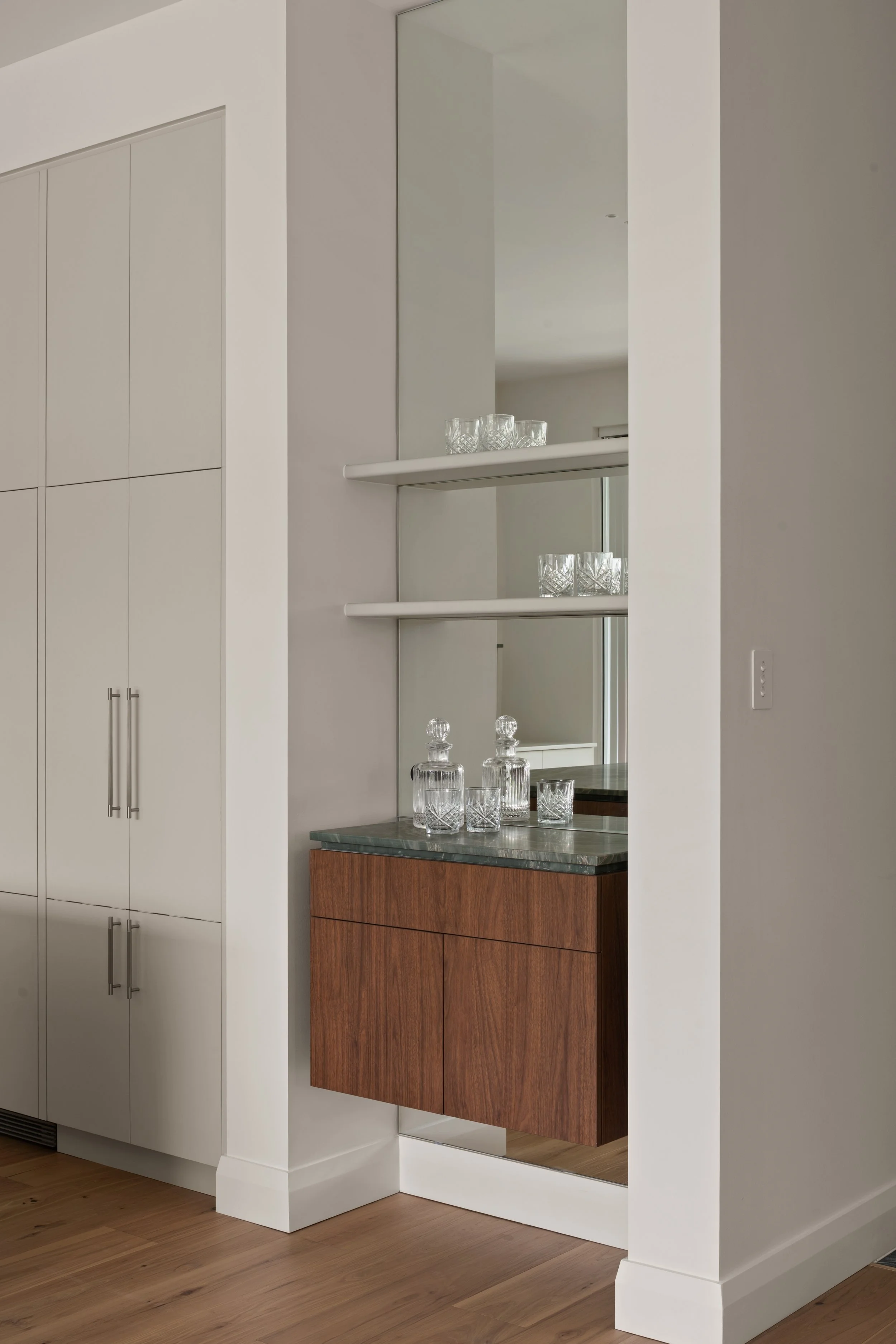 Built-in drinks cabinet with glass shelving and a timber base in Glenelg North