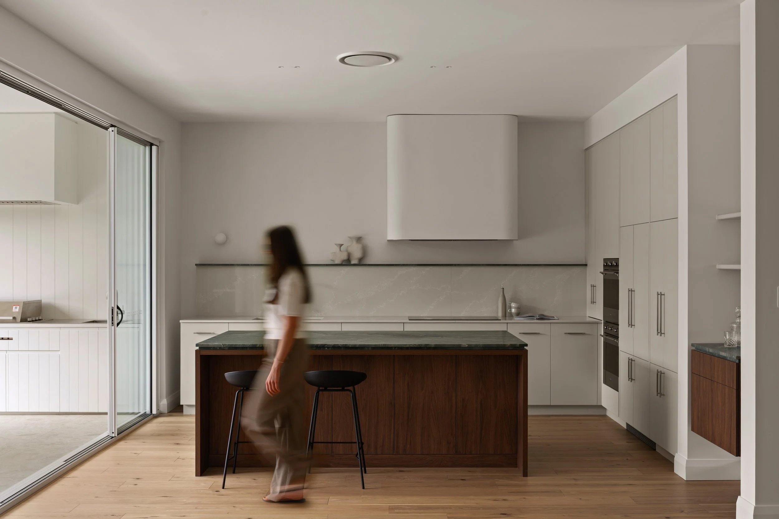 Pale kitchen cabinetry and a timber island in Mastacon’s Glenelg North renovation and extension