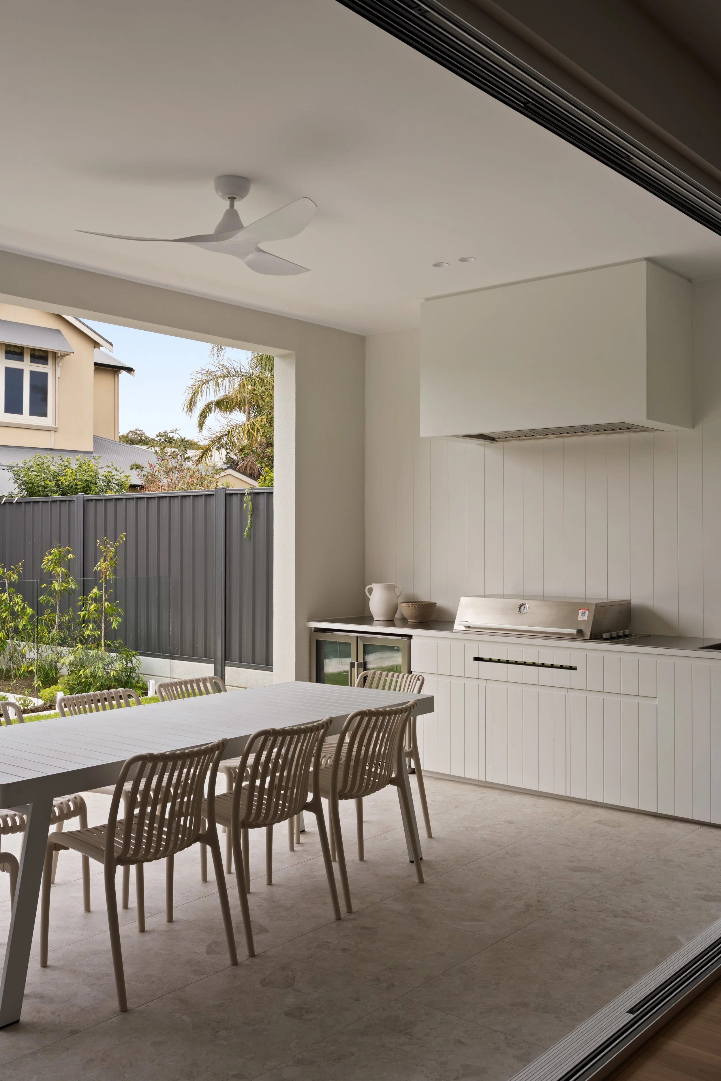 Dining area beside full-height glazing and pale kitchen cabinetry in Glenelg North