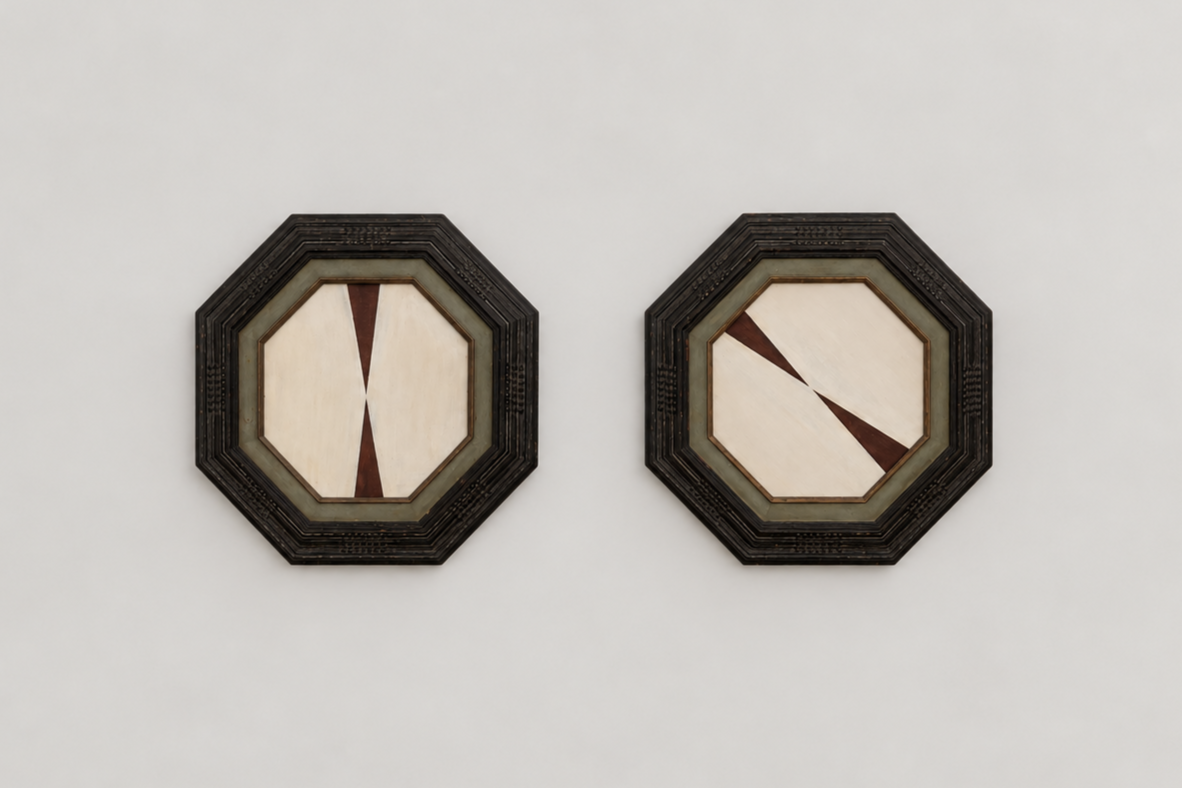 Two framed octagonal cream and red geometric abstract paintings on a plain white wall.
