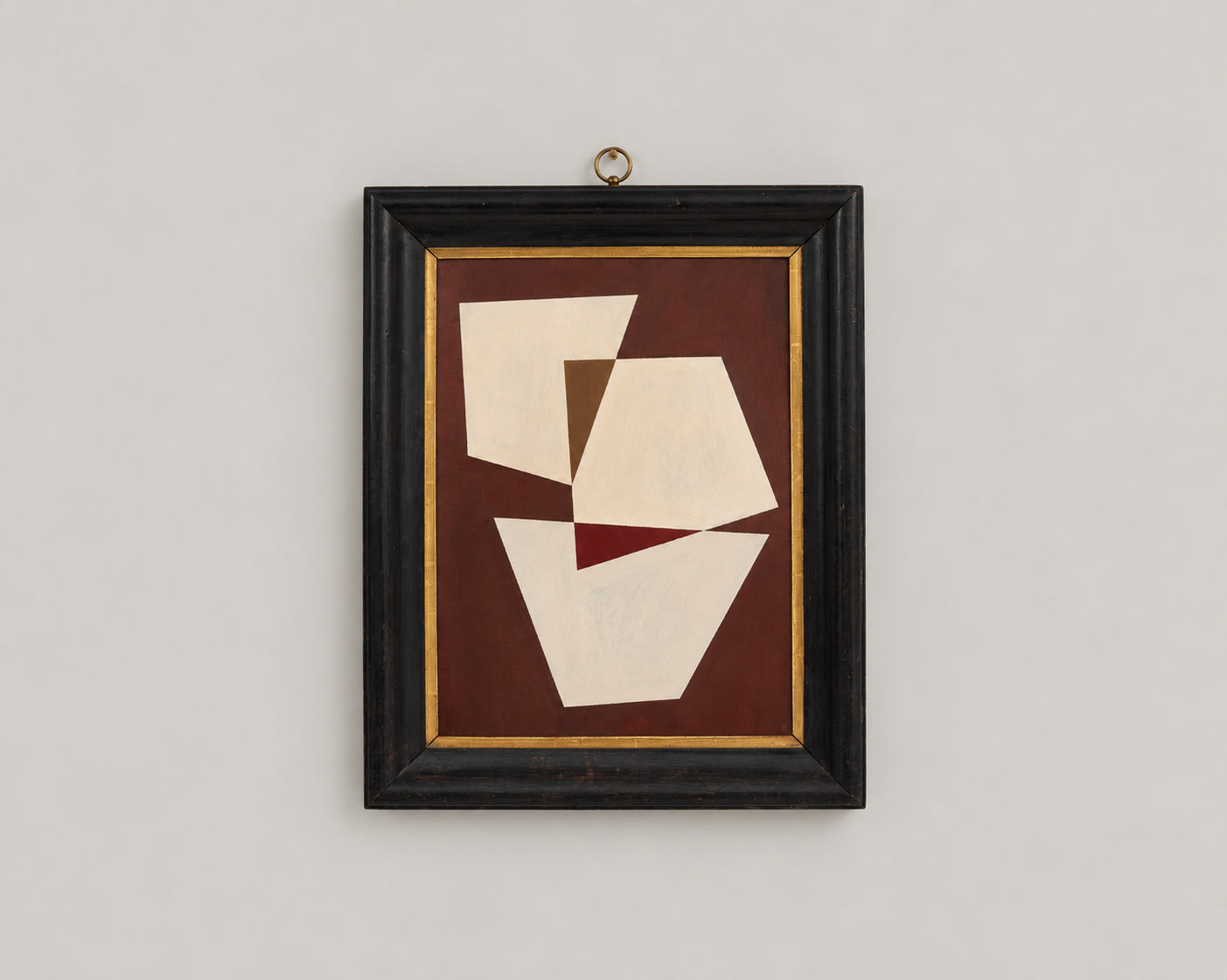 Abstract geometric painting with shapes in shades of cream and brown, framed in black with a gold inner edge, hanging on a gray wall.