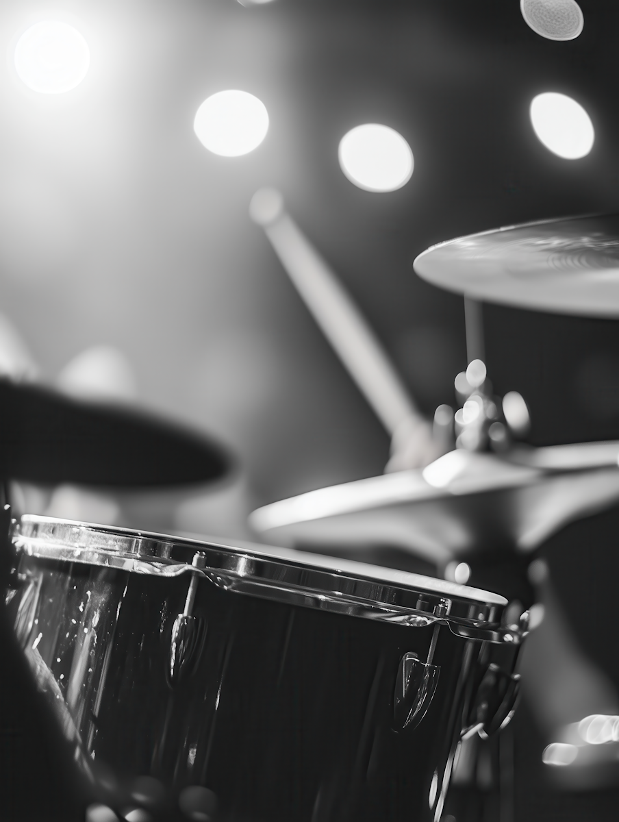 Close-up of a drum set with focus on the drum shell and cymbals, black and white photograph.