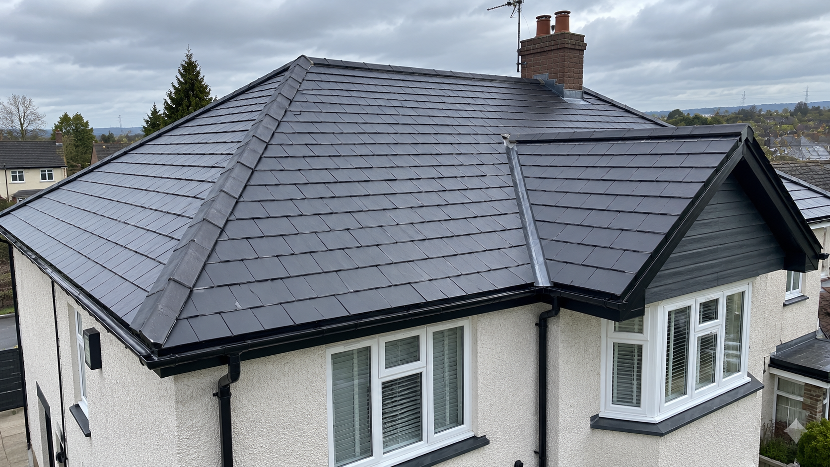 Charcoal Slate Roof Under Cloudy Skies.png