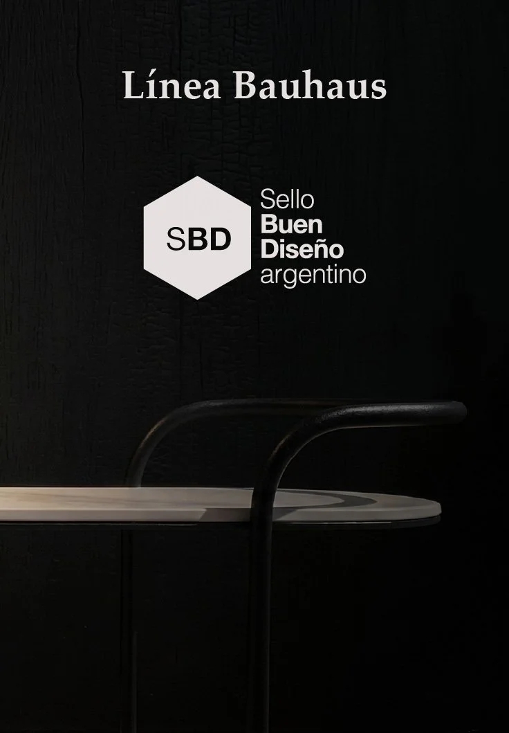 Imagen de una placa negra con letras blancas que dice 'Línea Bauhaus' y un logo hexagonal con las letras SBD, con la inscripción 'Sello Buen Diseño argentino'.