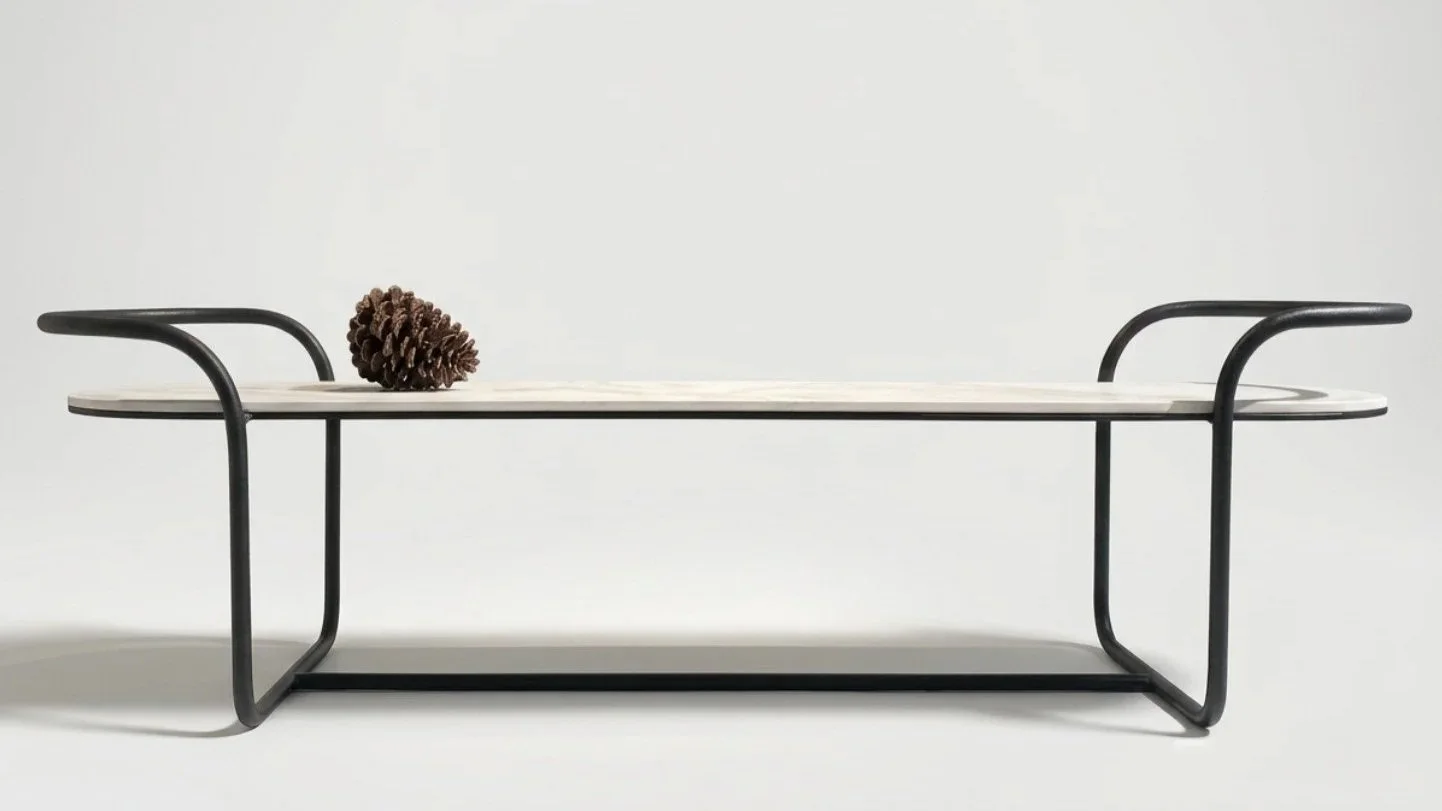 Mesa moderna con estructura de metal negro, superficie de mármol claro y piña en la superficie.