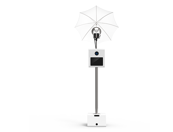 Front view of the Legacy Photo Booth with umbrella lighting, camera, touchscreen and white stand.