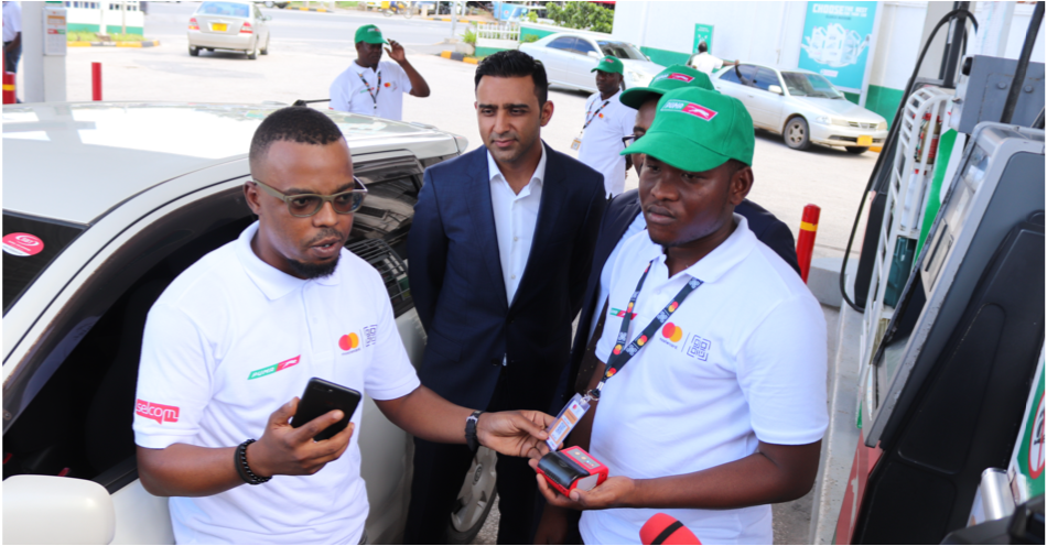 Left, Selcom Head of Marketing, Baguma Ambari and Puma Attendant, Hamisi Ali demonstrate a Mastercard QR payment at Puma Upanga during #BombaWeekends launch.