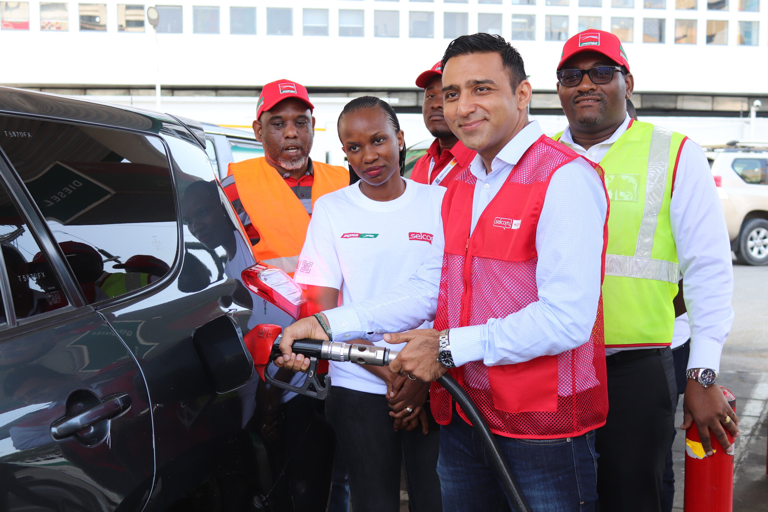 Selcom Executive Director, Mr Sameer Hirji fuels one of the “Full Tenki” reward recipients during the a short reward ceremony held at Puma Upanga in Dar es Salaam. Looking on is Puma Energy Tanzania Managing Director, Mr. Dominic Dhanah (L), Puma En…