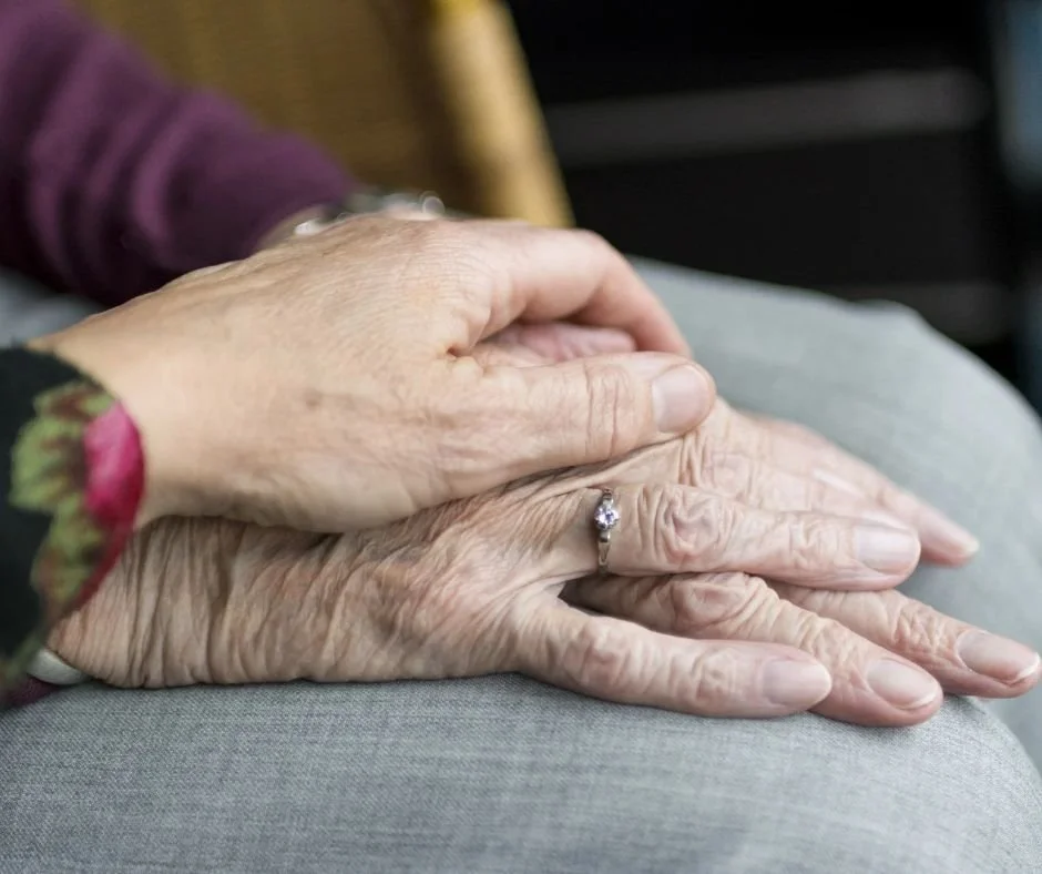 two hands on a lap, showing support