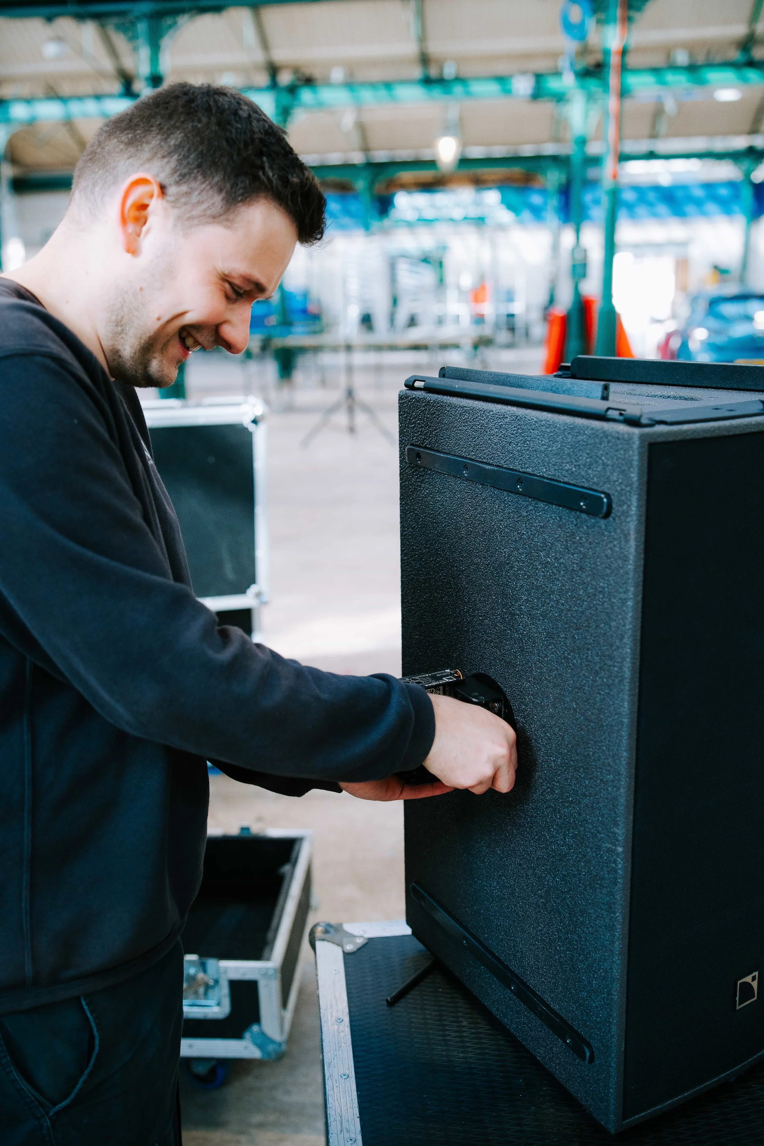 AXL crew member preparing a PA speaker in the warehouse ahead of an event hire