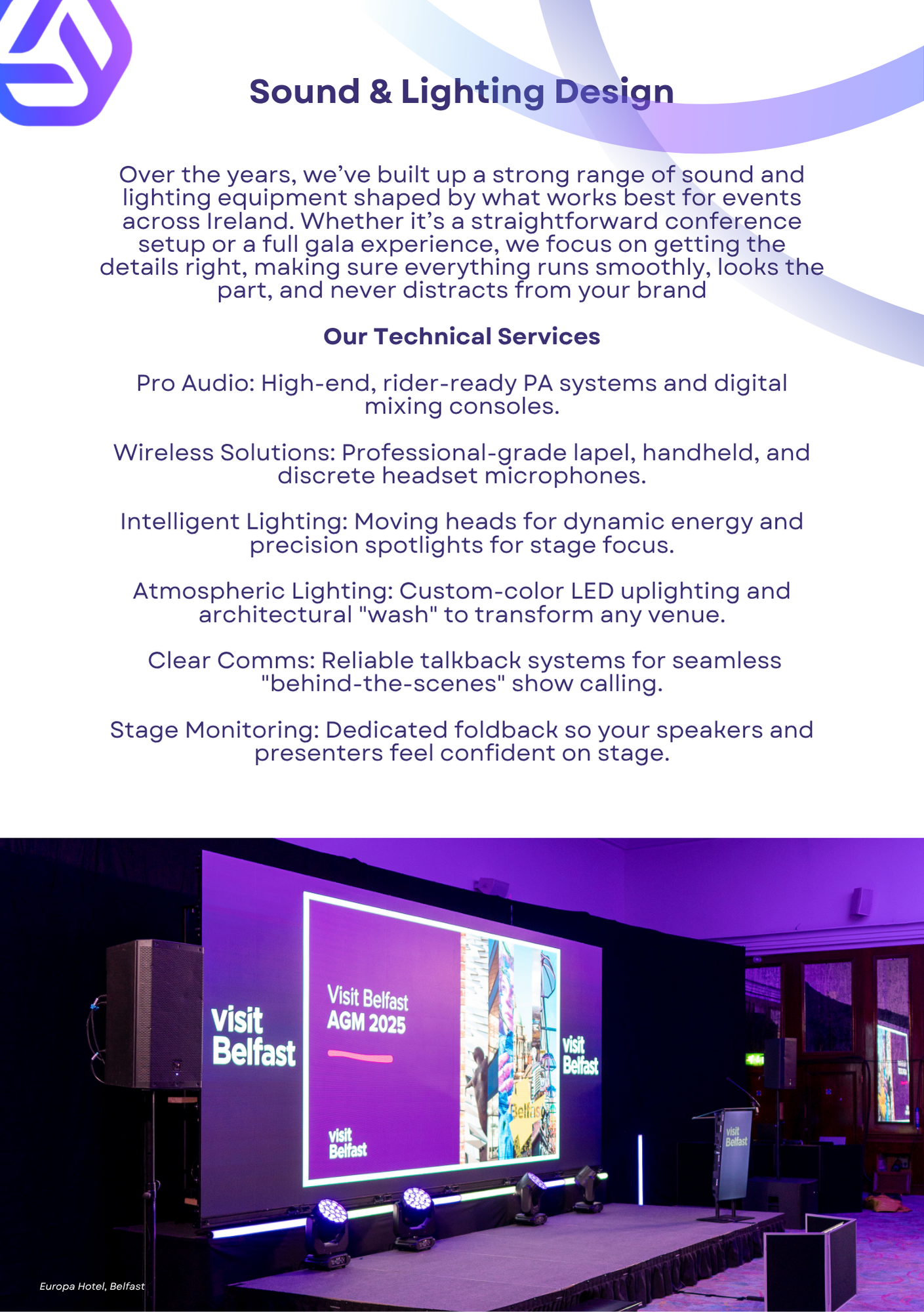 Conference room stage with large screen displaying 'Visit Belfast AGM 2025' and 'Visit Belfast' logos, purple lighting, and stage equipment.
