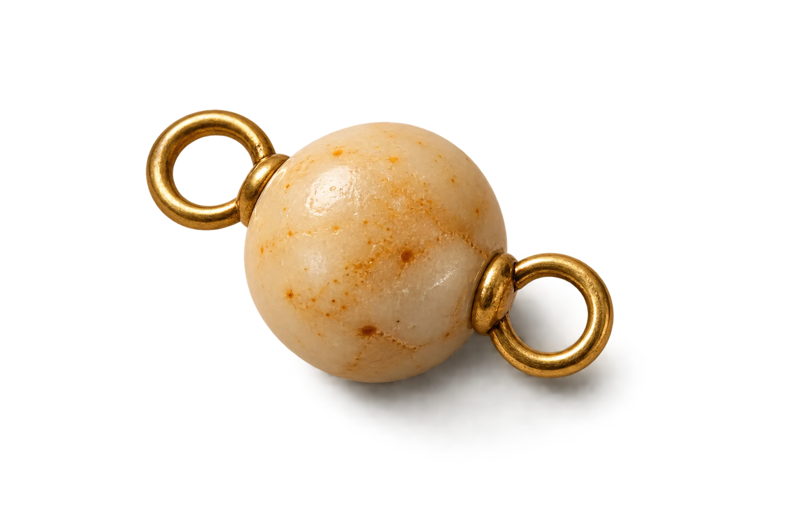Close-up of a marble with gold rings attached to it, isolated on a black background.