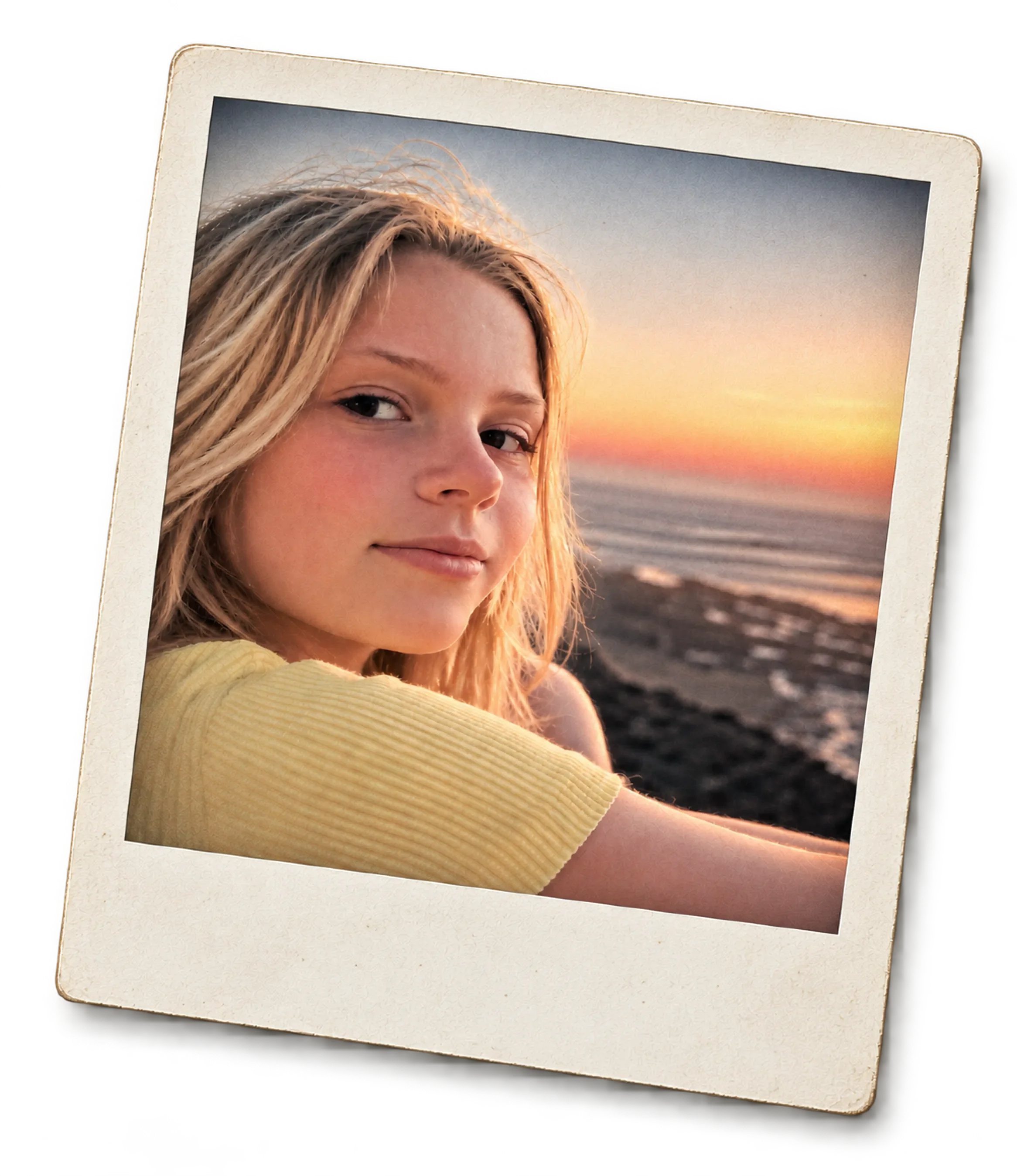 A woman with wavy blonde hair looking at the camera during sunset at the beach, framed in a Polaroid-style border.