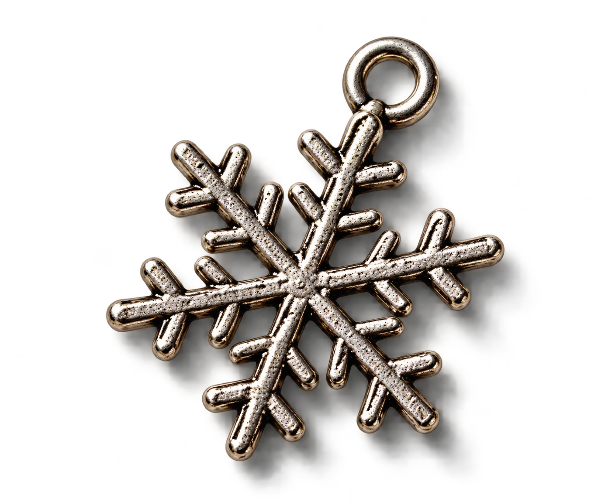 Close-up of metallic snowflake-shaped jewelry with embedded rhinestones on a black background.