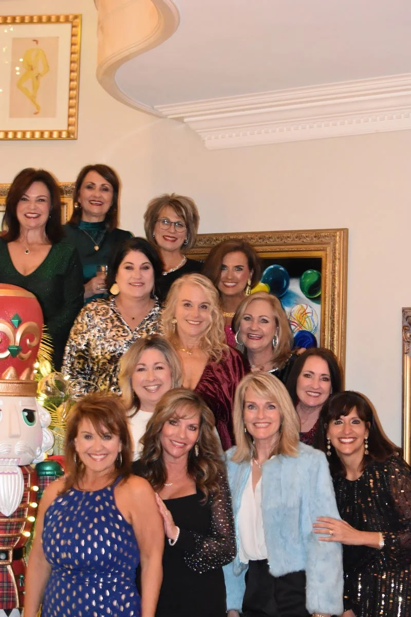Group of women celebrating at a party with Christmas decorations in the background.