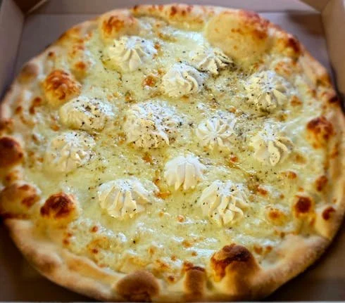 Cheese pizza with dollops of whipped cream topping.