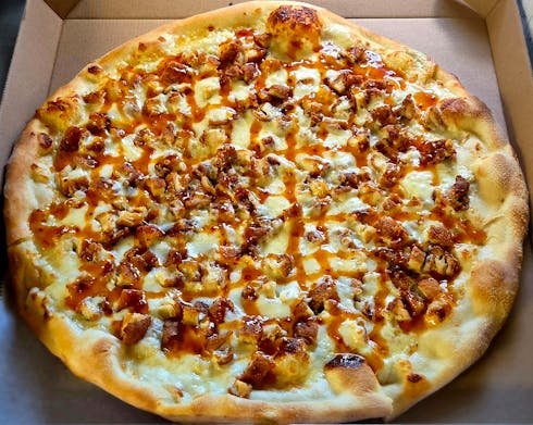 Pizza with cheese, chicken, and a drizzle of sauce