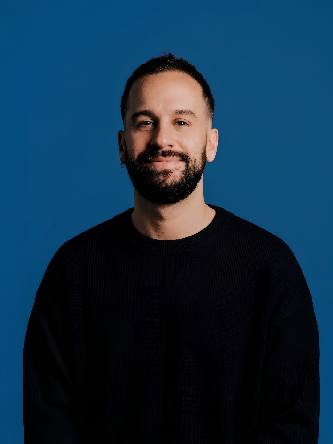Portrait of Luis Guevara, copywriter and content strategist, against a blue background.