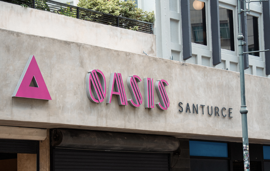 Exterior of the Oasis Santurce building featuring its pink and black signage.