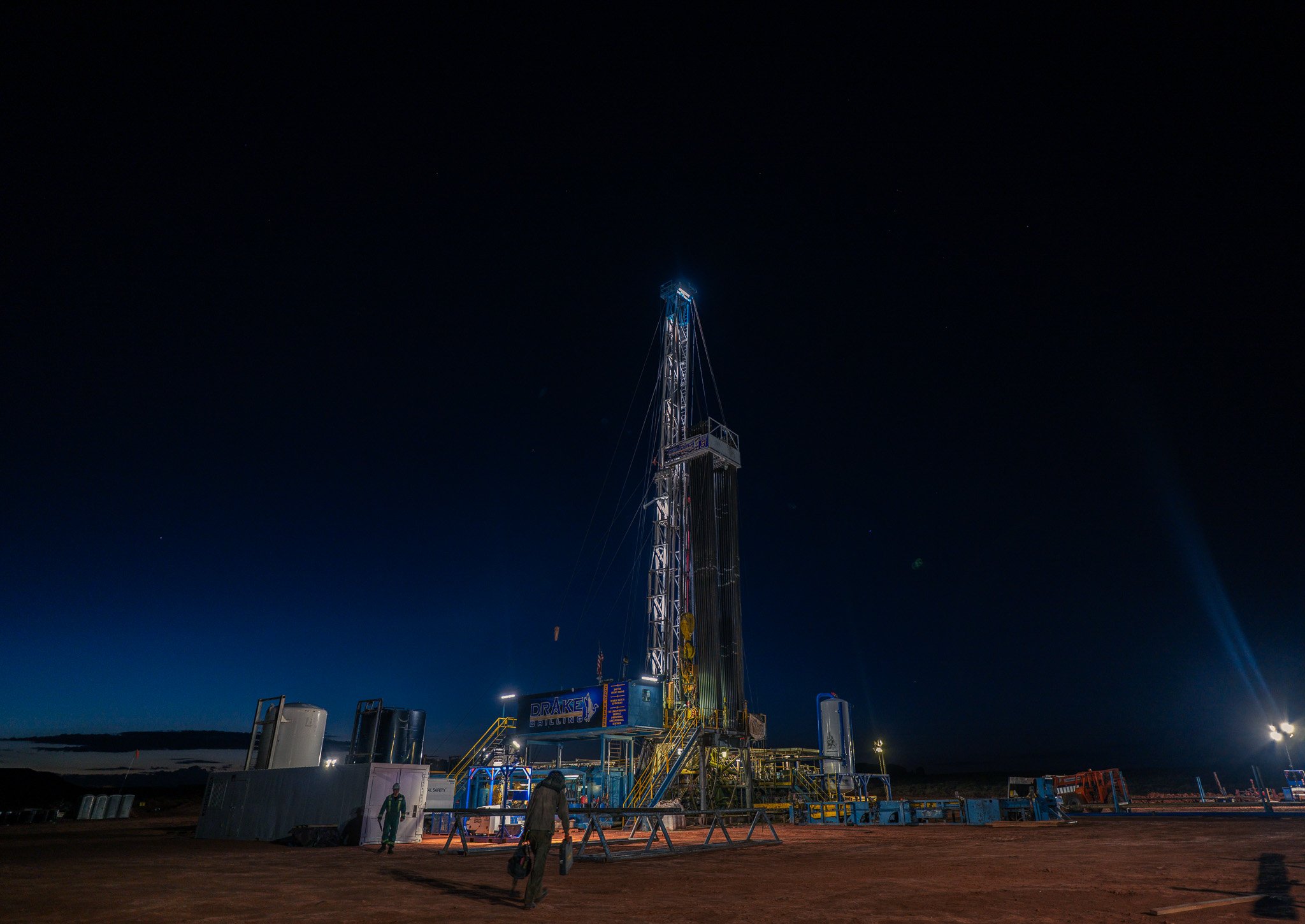 Nighttime view of a potash well with lights illuminating the structure, and a clear dark sky in the background.