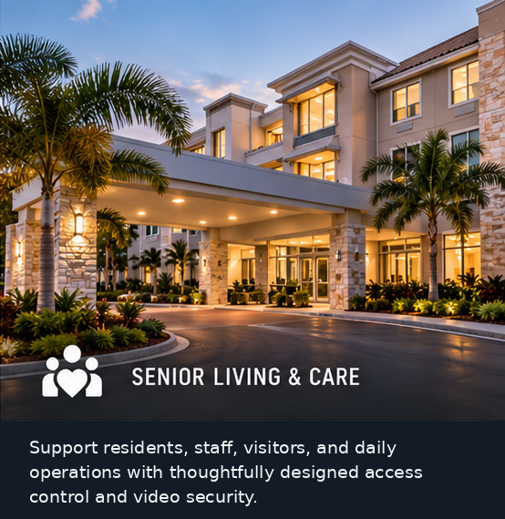 Senior living community entrance with landscaped drop-off and warm architectural lighting.