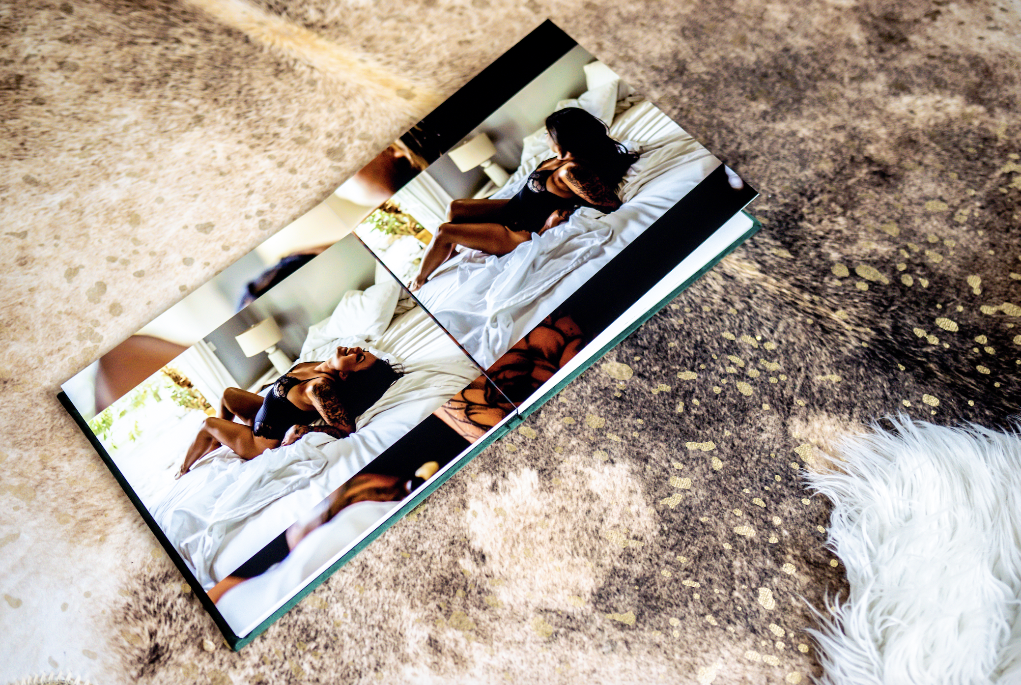 Open photo book featuring boudoir photography on a cowhide rug