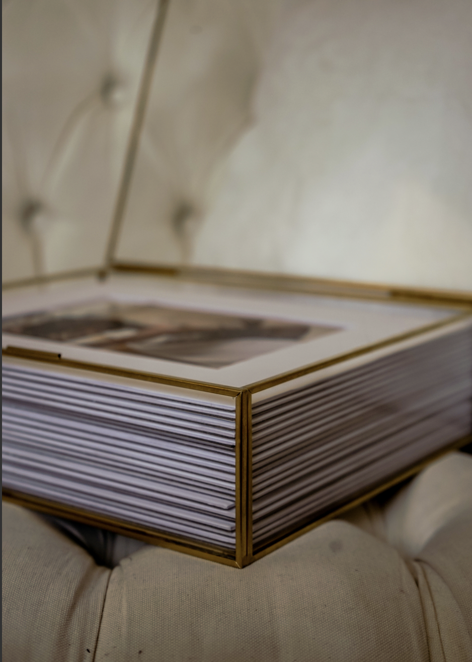Close-up of a closed book with gold edges on a tufted chair.