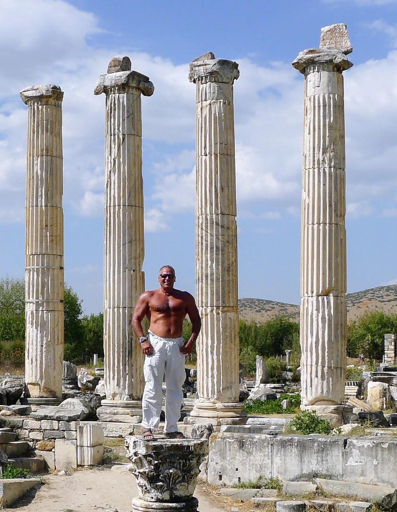 Nabil standing among four ancient marble columns at the Temple of Athena, Priene, Turkey, 2013