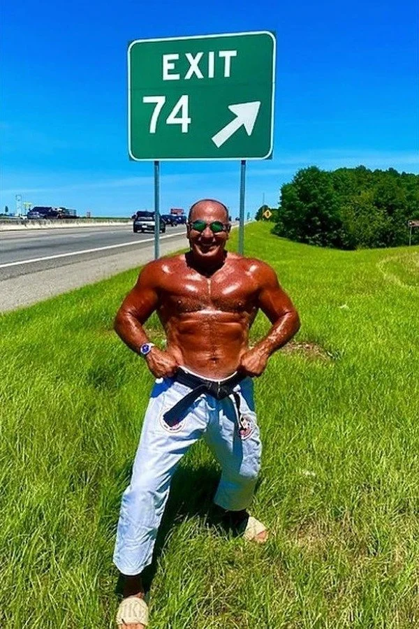 Nabil at age 74 beside an Exit 74 highway sign