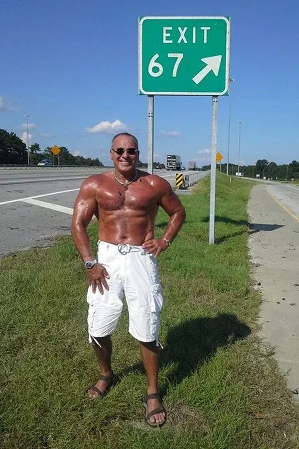 Nabil at age 67 beside an Exit 67 highway sign