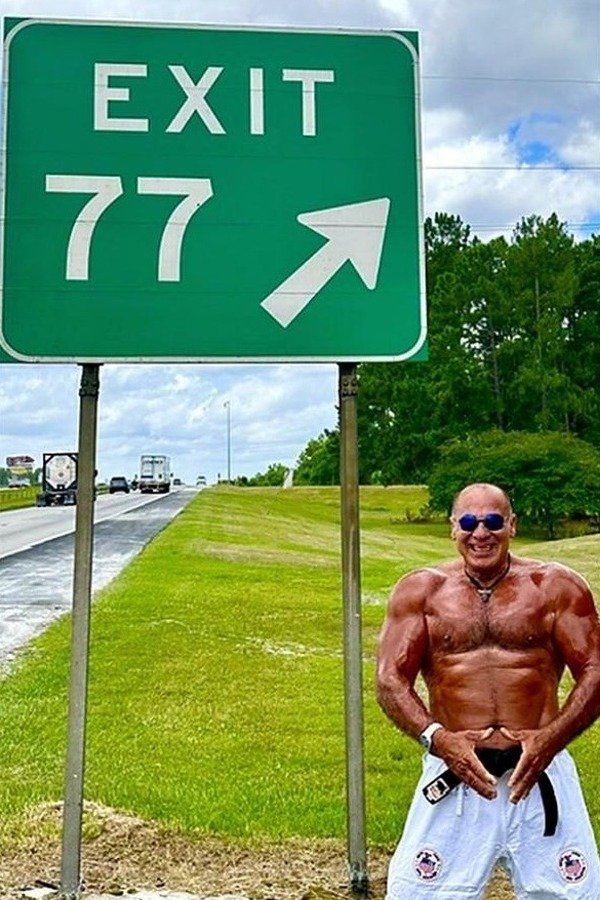 Nabil at age 77 beside an Exit 77 highway sign