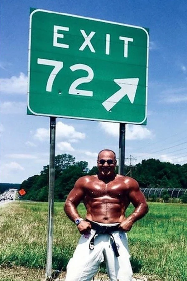 Nabil at age 72 beside an Exit 72 highway sign