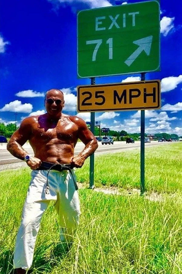 Nabil at age 71 beside an Exit 71 highway sign