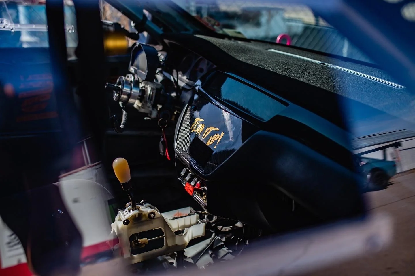 Close-up of a car's racing interior showing steering and gear shifter.