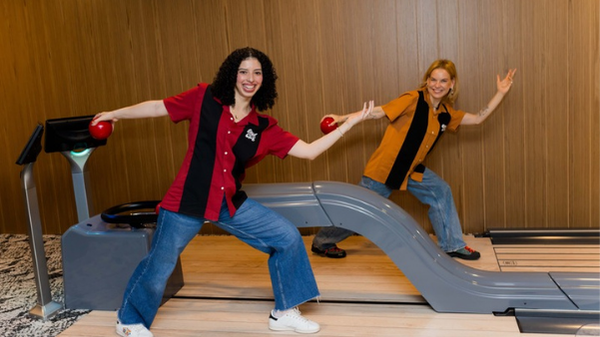 Jackie and Lindsay standing together in a bowling alley.