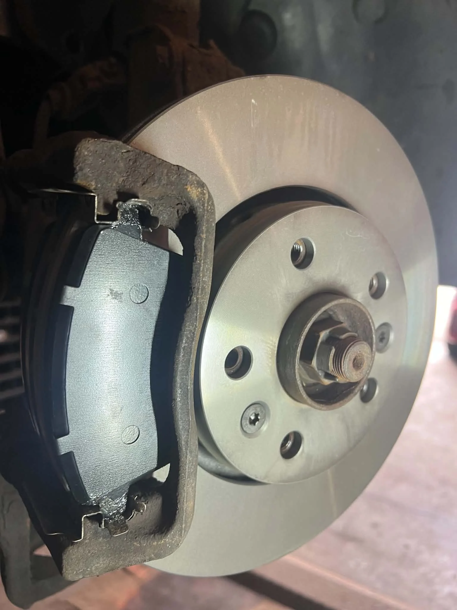 Close-up view of a mechanical component with metal and plastic parts, including gears and a metallic disc, possibly part of a machine or engine assembly.