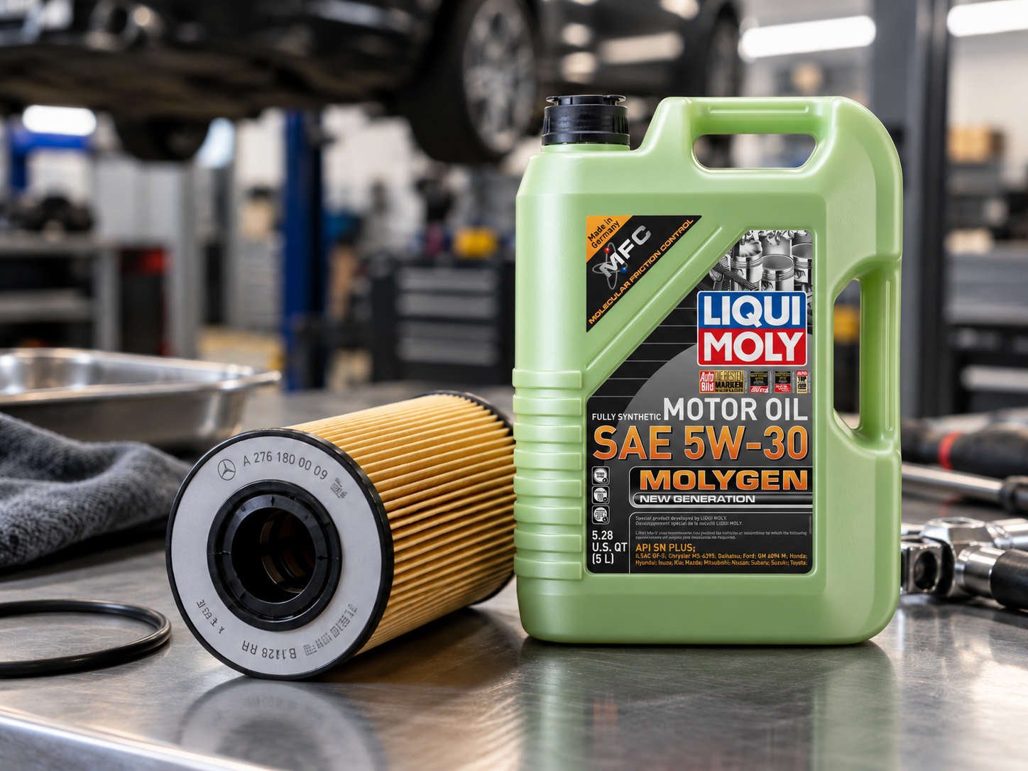 Container of Liqui Moly fully synthetic motor oil SAE 5W-30 and an oil filter on a workbench in an auto repair shop.