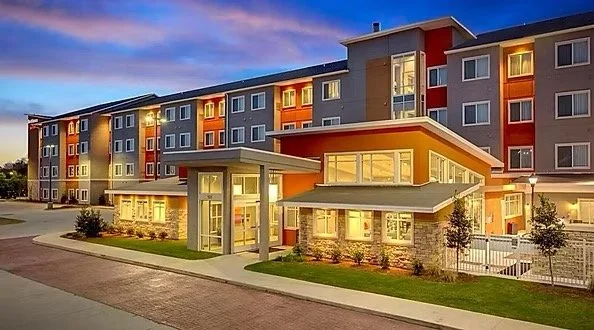 Exterior view of a modern multi-story apartment building during twilight